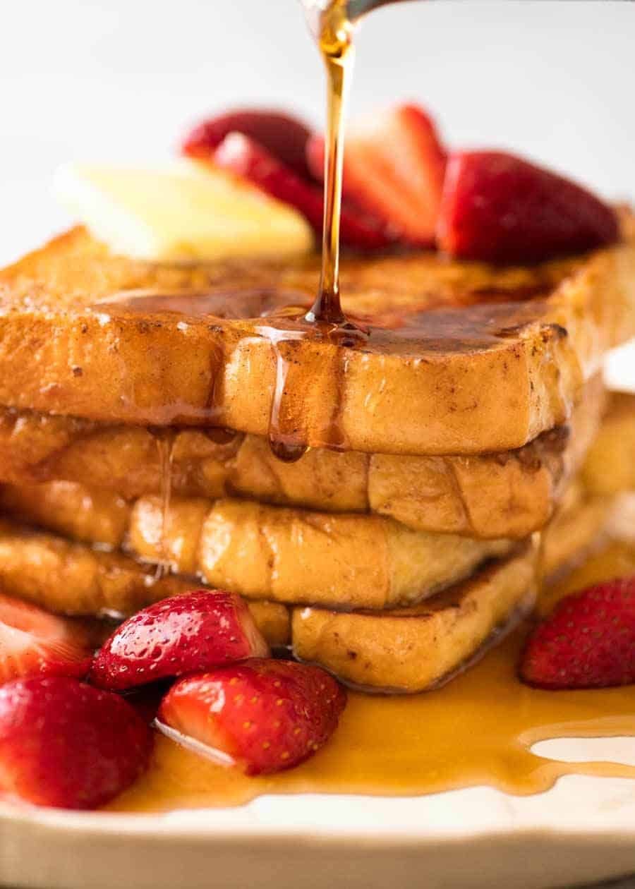 Maple syrup being poured over a stack of French Toast