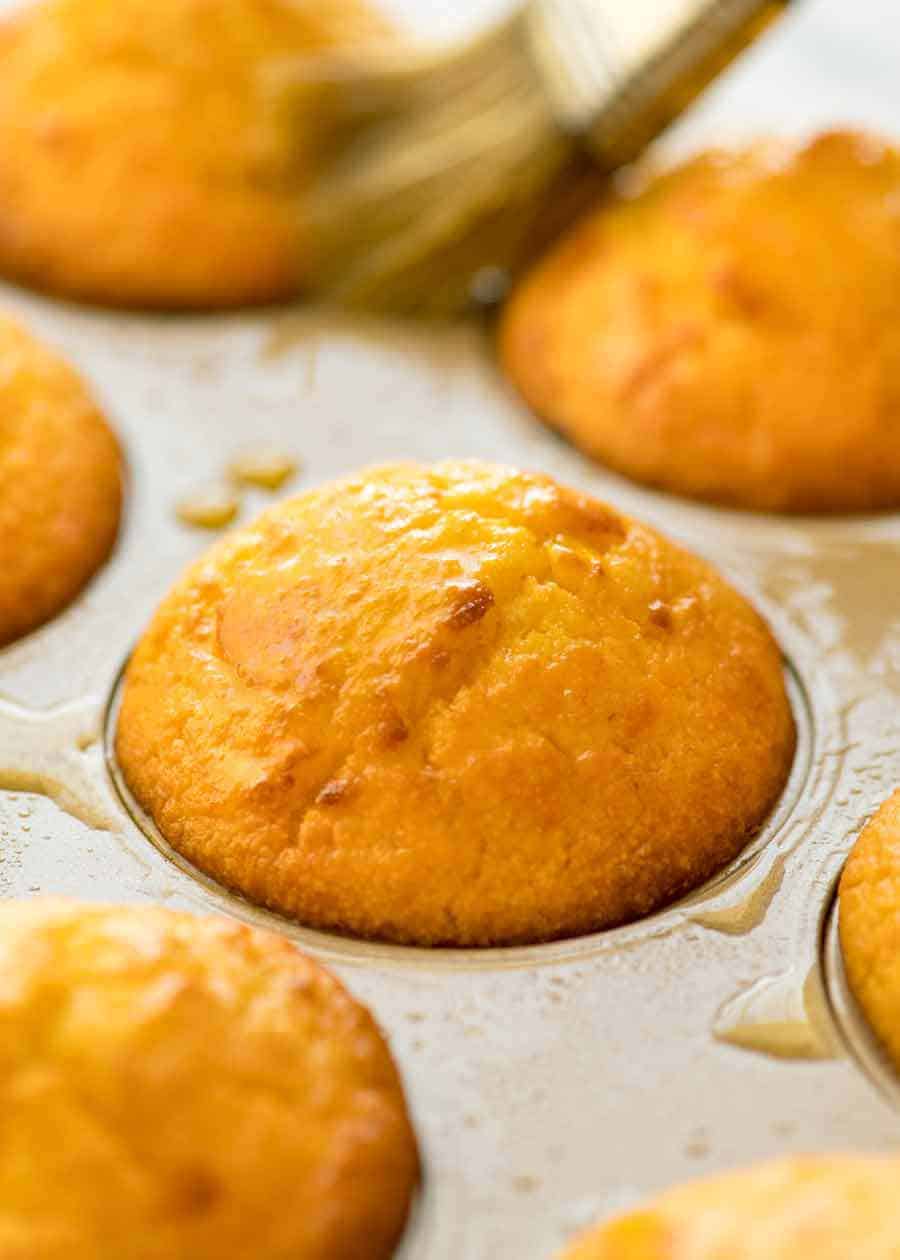 Close up of Cornbread Muffins in a muffin tin brushed with butter