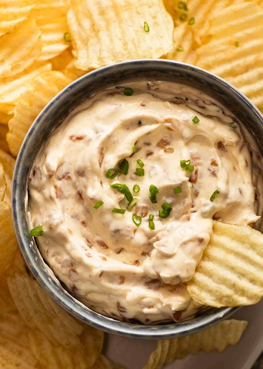 Homemade Onion Dip in a bowl surrounded by crinkle cut potato chips, ready to be served
