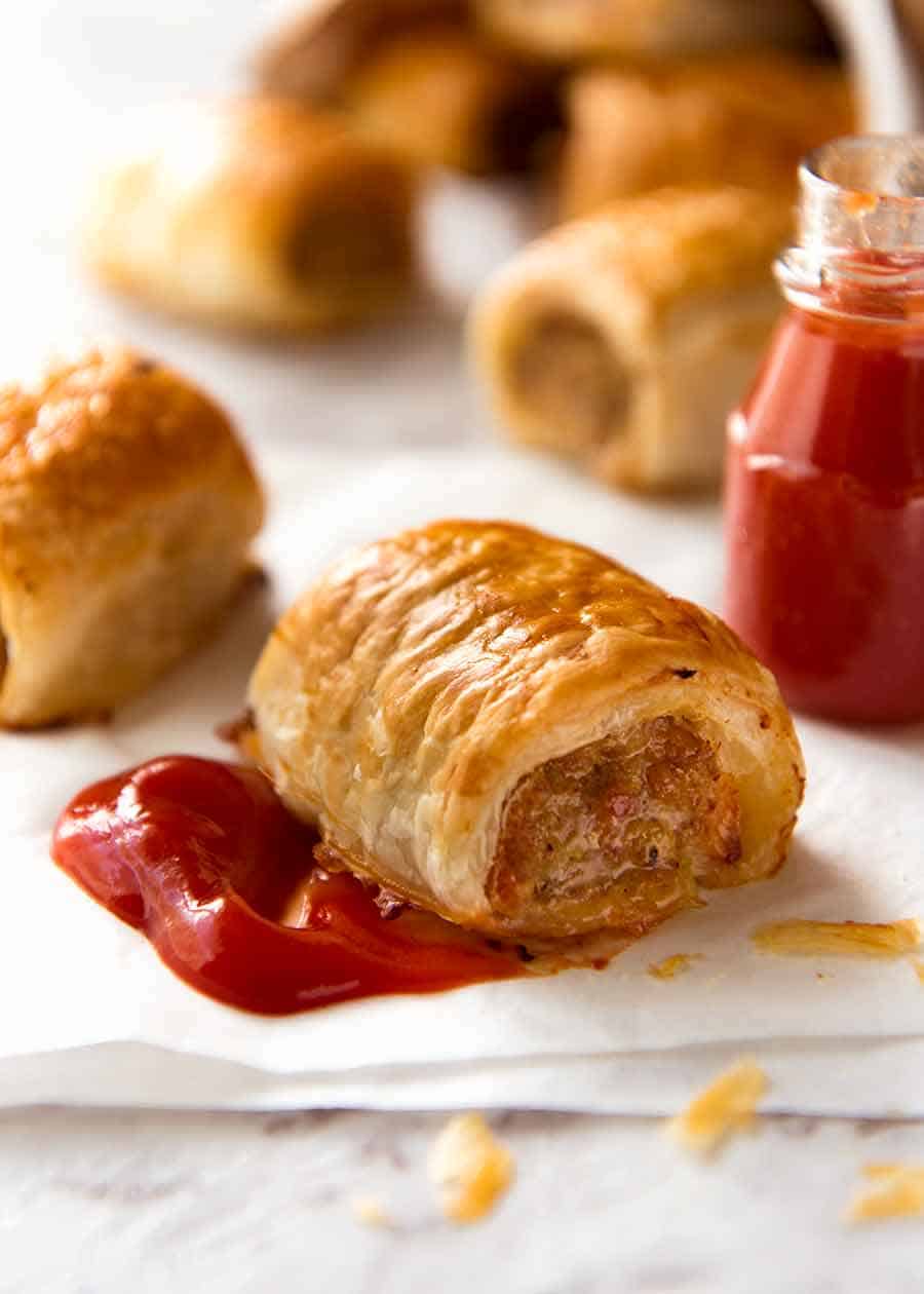 Close up of sausage roll in tomato sauce