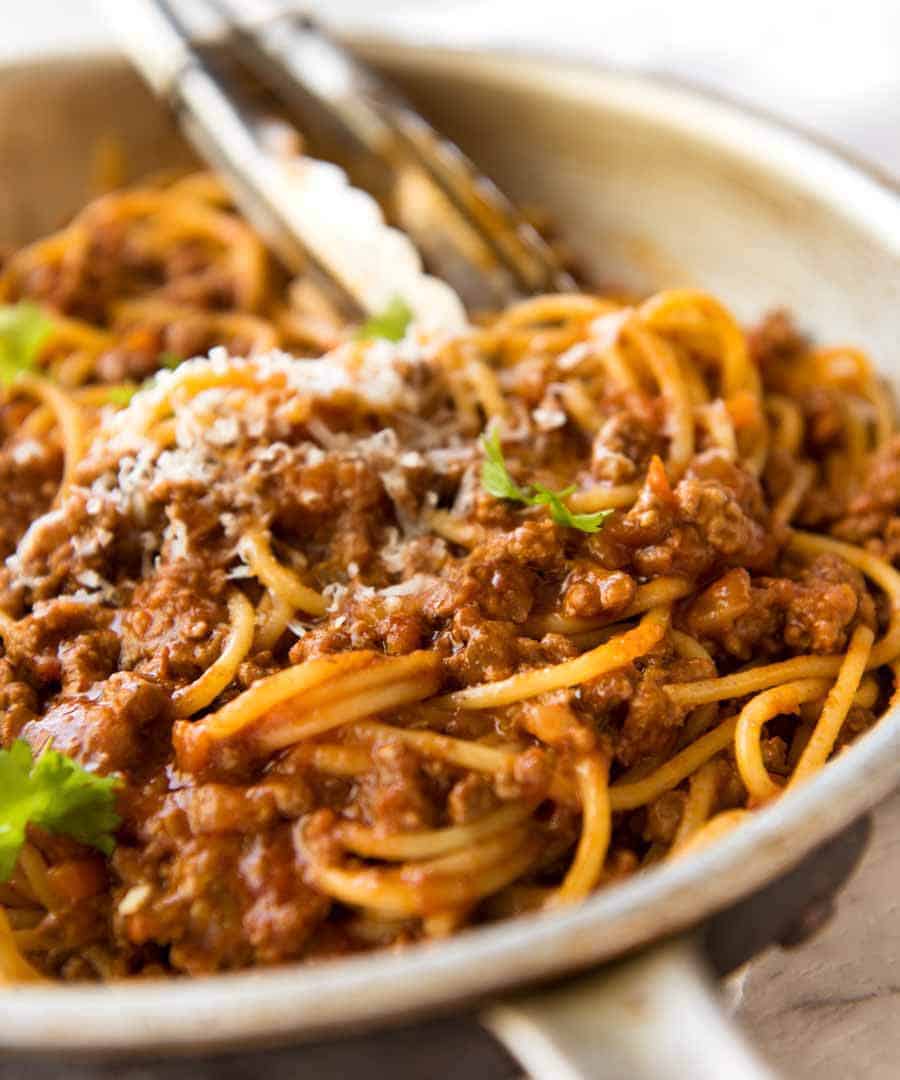 Bolognese sauce and pasta mixed in a pan, ready to serve.