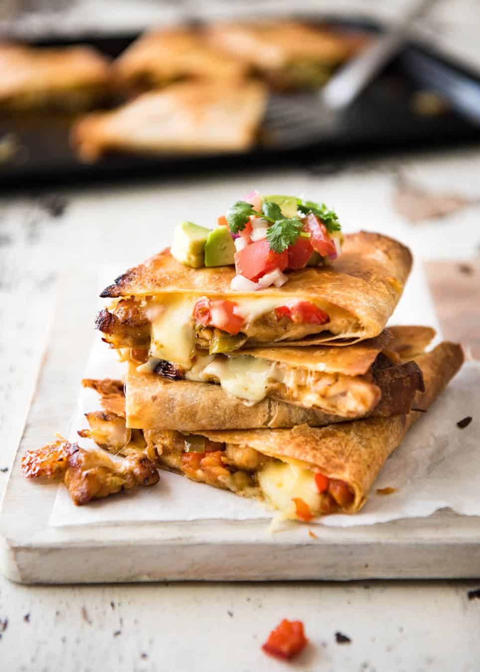 Crispy Oven Baked Chicken Quesadillas - This is how to make multiple Quesadillas at the same time! Crispy on the outside, stuffed with Mexican seasoned chicken and capsicum / bell peppers (and cheese of course!) www.recipetineats.com