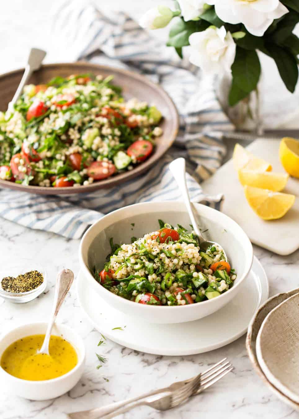 This Israeli Couscous Salad is fabulously addictive! Tender, flavour infused beads of couscous tossed with spinach, tomato, cucumber, herbs and a fresh lemon dressing. Summer in a bowl! www.recipetineats.com