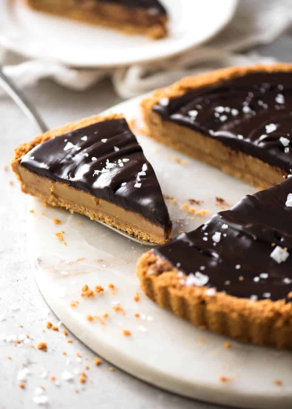 A sinfully decadent Salted Caramel Tart with a creamy soft salted caramel filling topped with luxurious chocolate ganache. Just SIX ingredients! www.recipetineats.com
