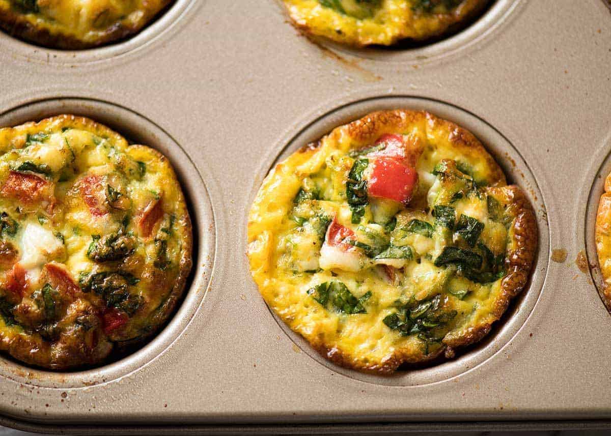Healthy doesn't have to be bland! These Healthy Egg Muffins are a great grab & go breakfast option. Egg, spinach, feta, cherry tomatoes and bell peppers/capsicum. www.recipetineats.com