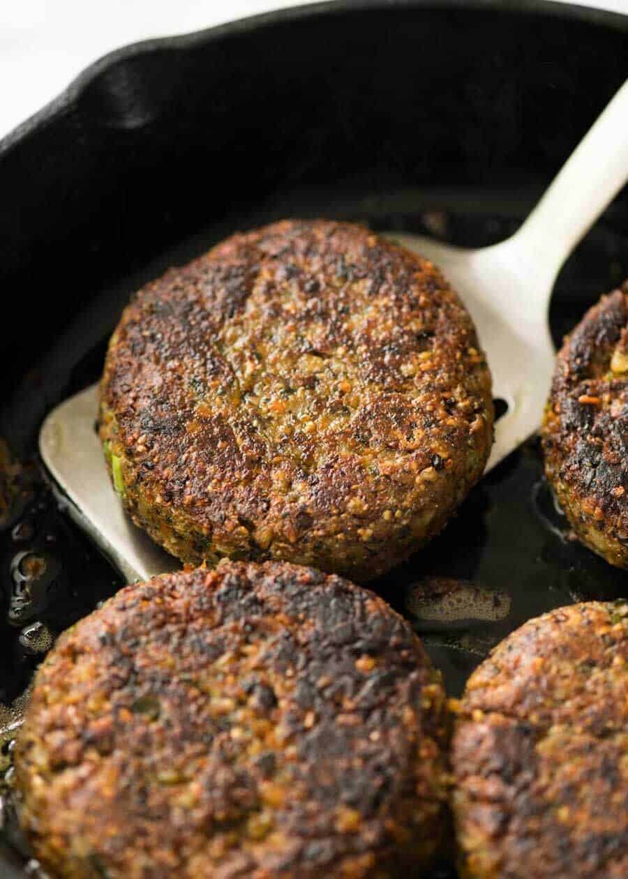 Close up of veggie burgers in a black skillet.