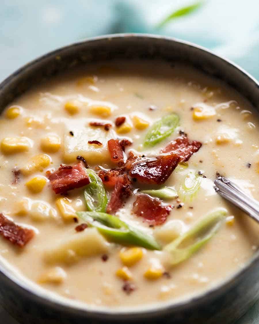 The most incredible super fast easy Corn Chowder in a rustic brown bowl, with potato and bacon, ready to be eaten!